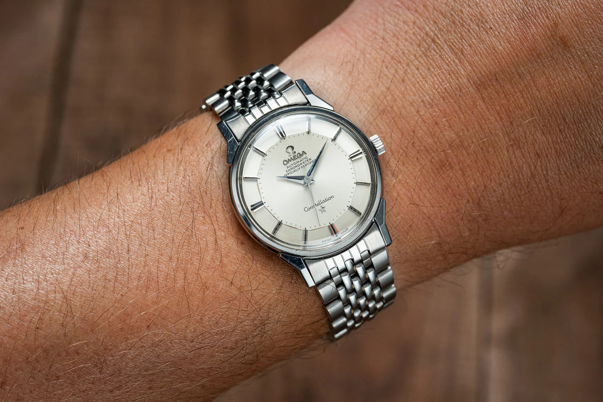 Omega Constellation automatic stainless steel watch with silver dial and Beads of Rice bracelet worn on wrist