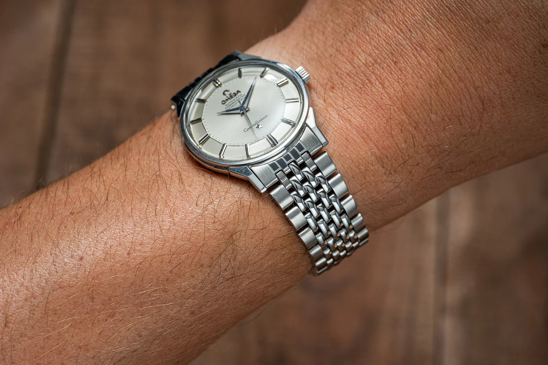 Omega Constellation stainless steel watch with silver dial and beads of rice bracelet worn on wrist
