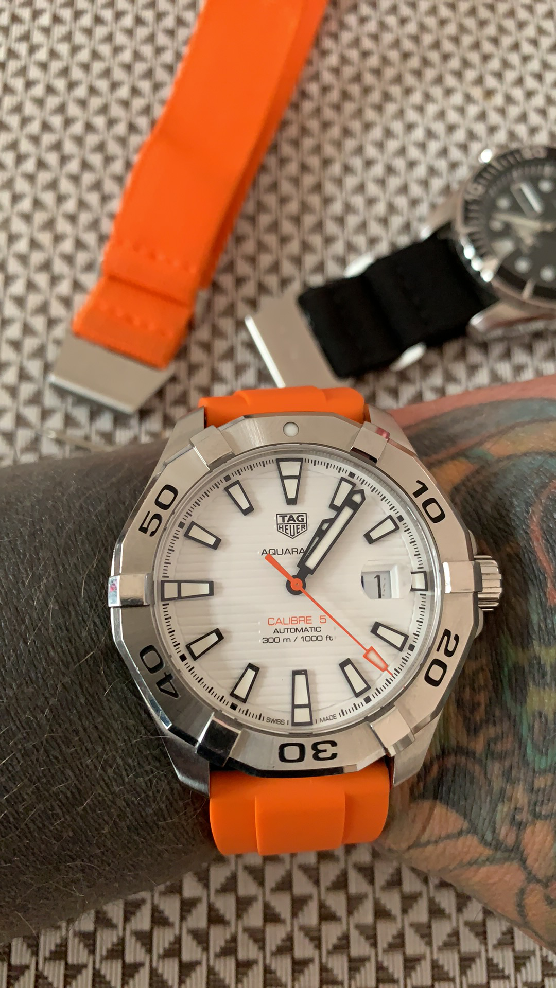 Tag Heuer Aquaracet Calibre 5 automatic dive watch with orange rubber strap and white dial