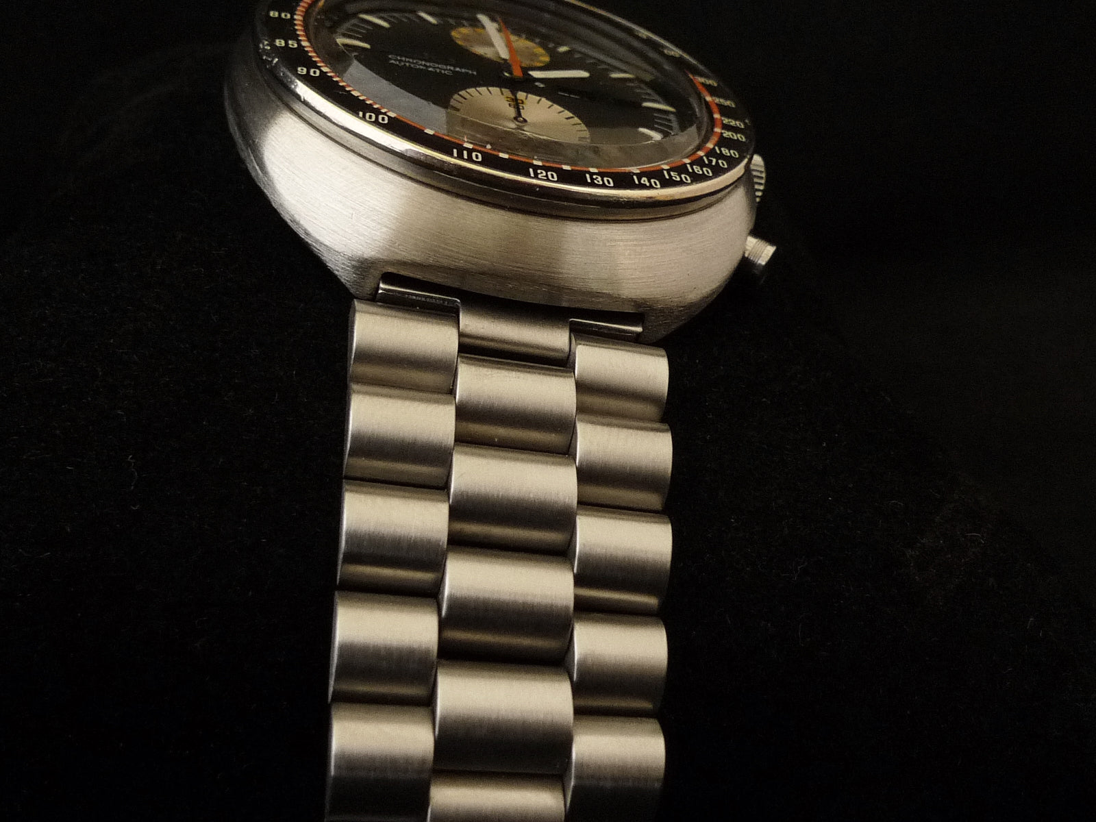 Vintage Seiko 6138 chronograph watch with brushed stainless steel case, black dial, and three-link steel bracelet