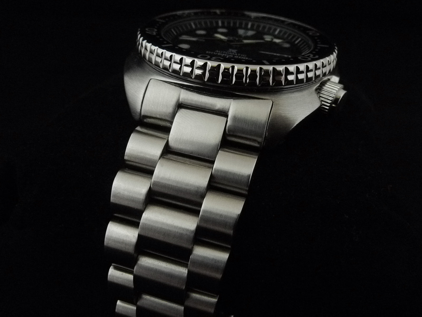 Seiko 6309 SRP dive watch with brushed stainless steel Uncle Lincoln bracelet and black dial on black background