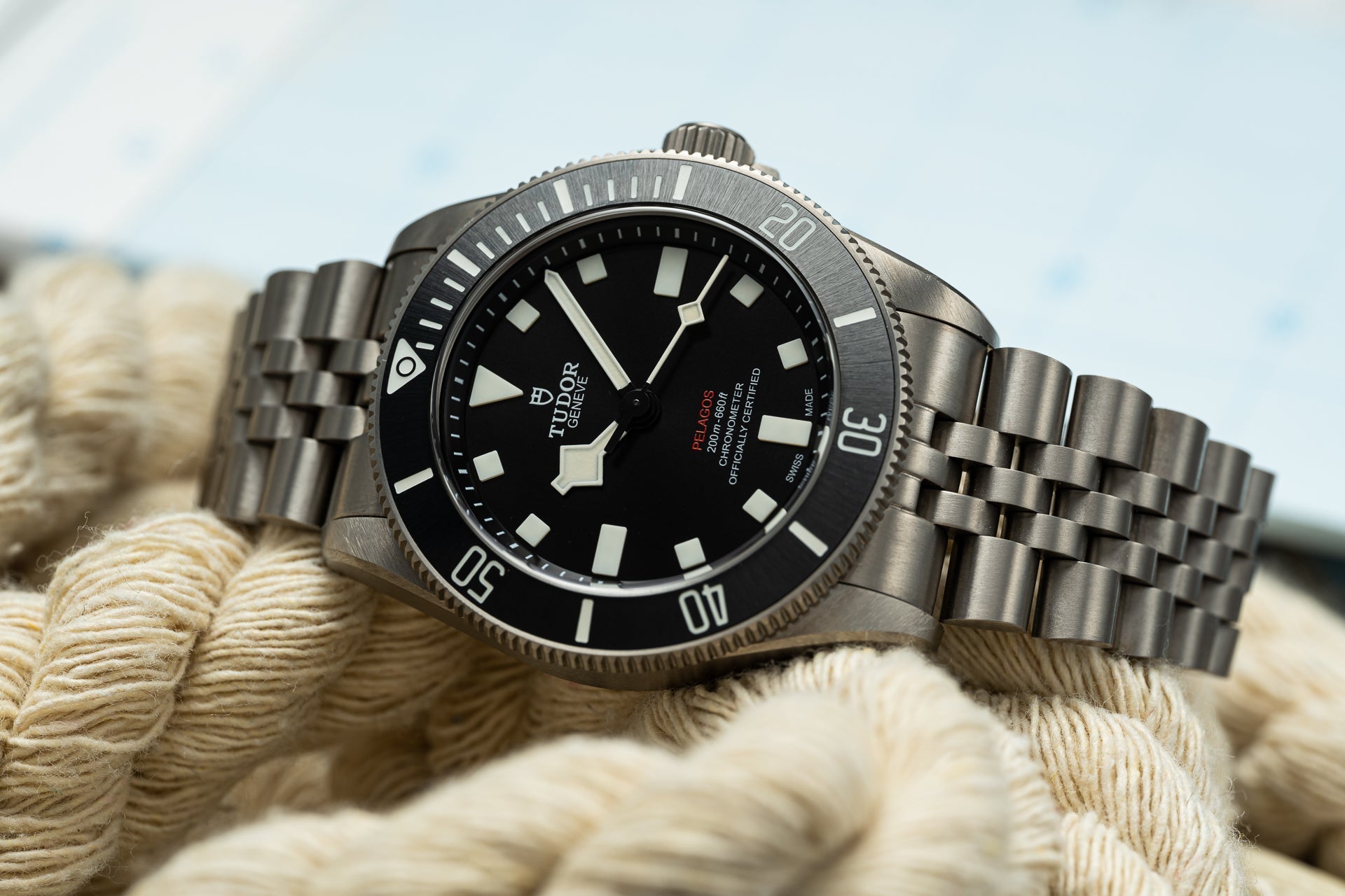Tudor Pelagos 39mm titanium dive watch with black dial on steel bracelet, displayed on nautical rope outdoors