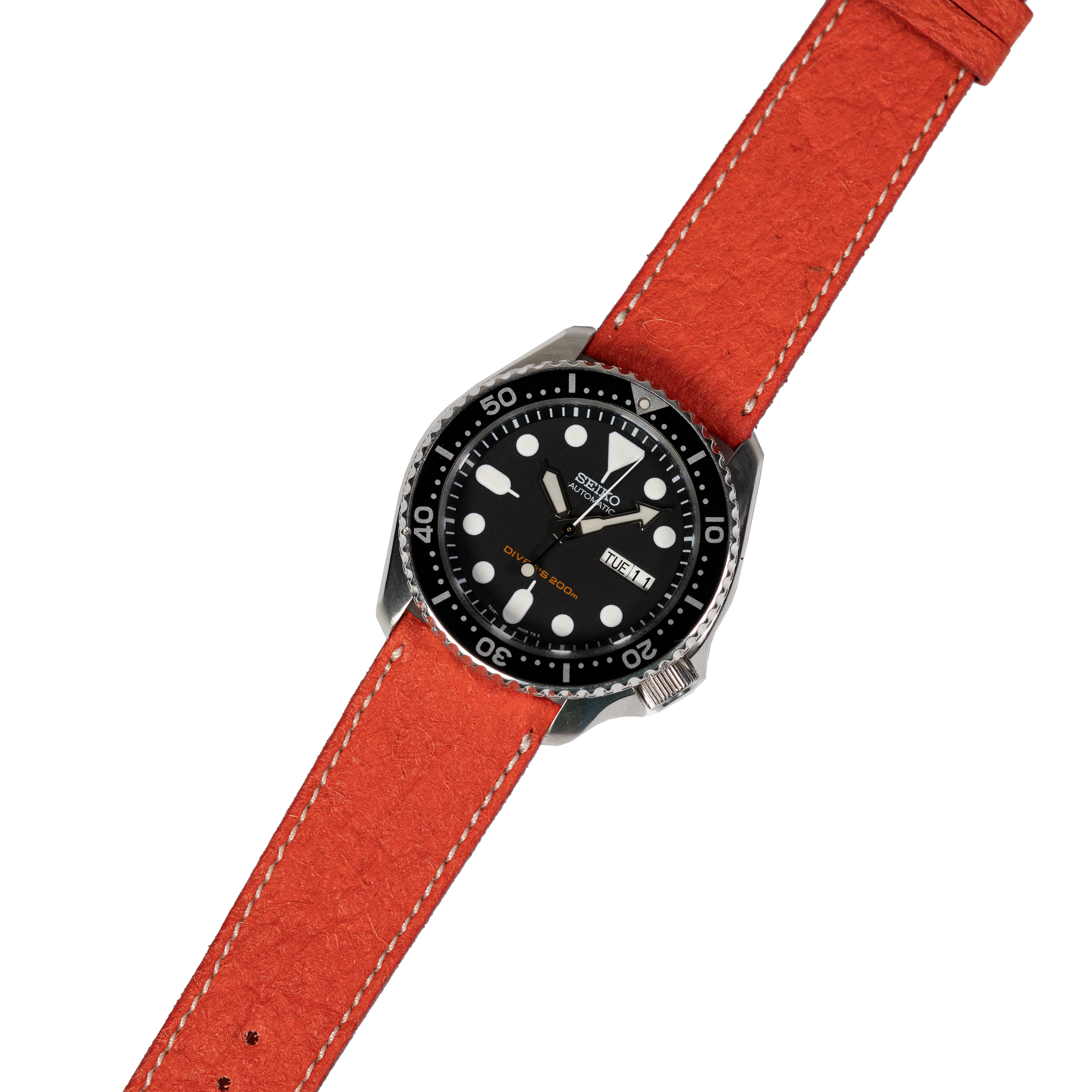 Seiko dive watch with black dial, rotating bezel, luminous hands and hour markers, red leather strap with white stitching