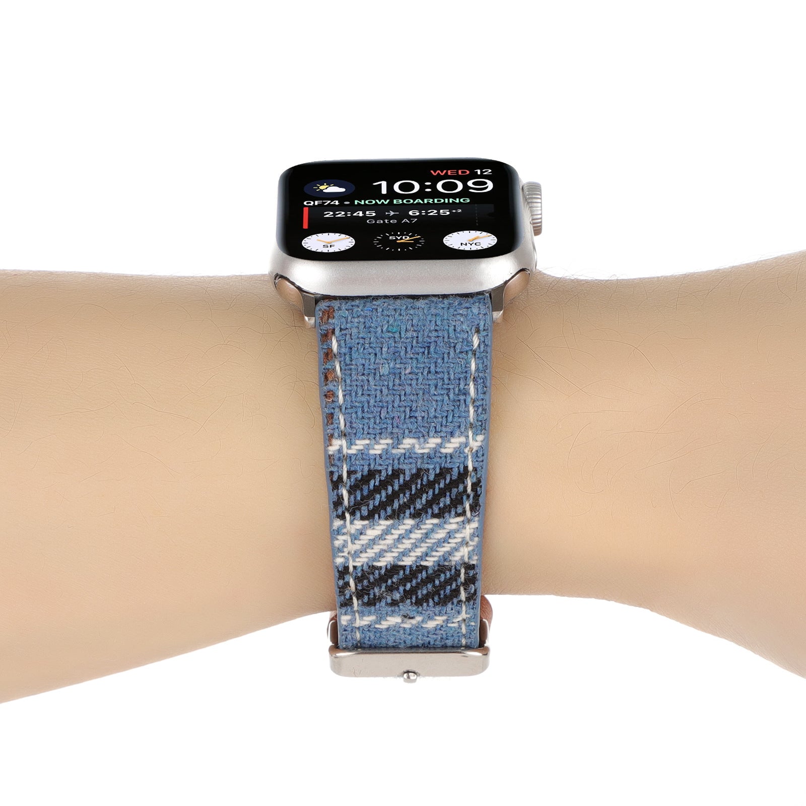 Silver smartwatch with plaid woven fabric band in blue and cream, displaying time and flight information on screen, worn on wrist
