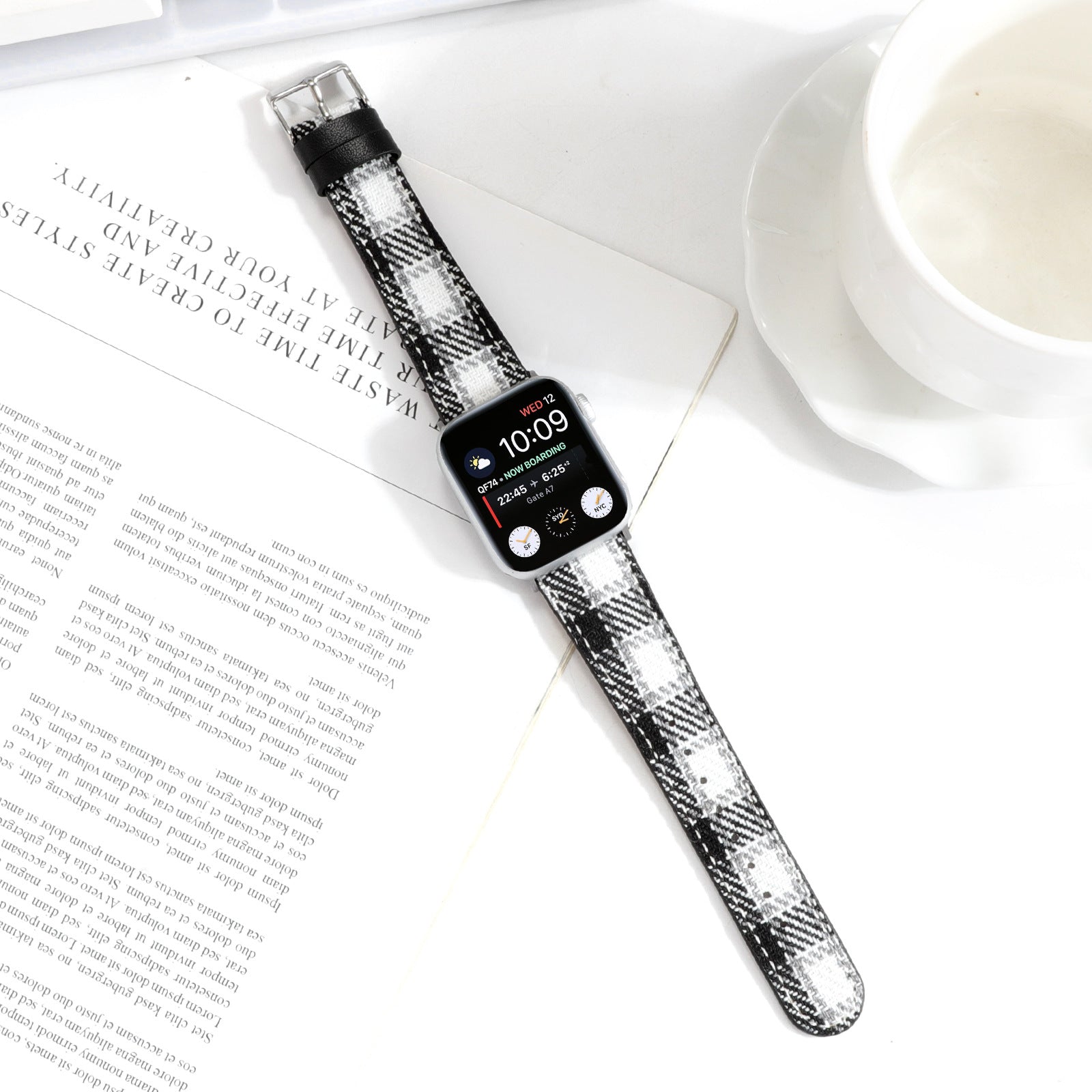 Apple Watch with black and white plaid check fabric band displaying time on screen