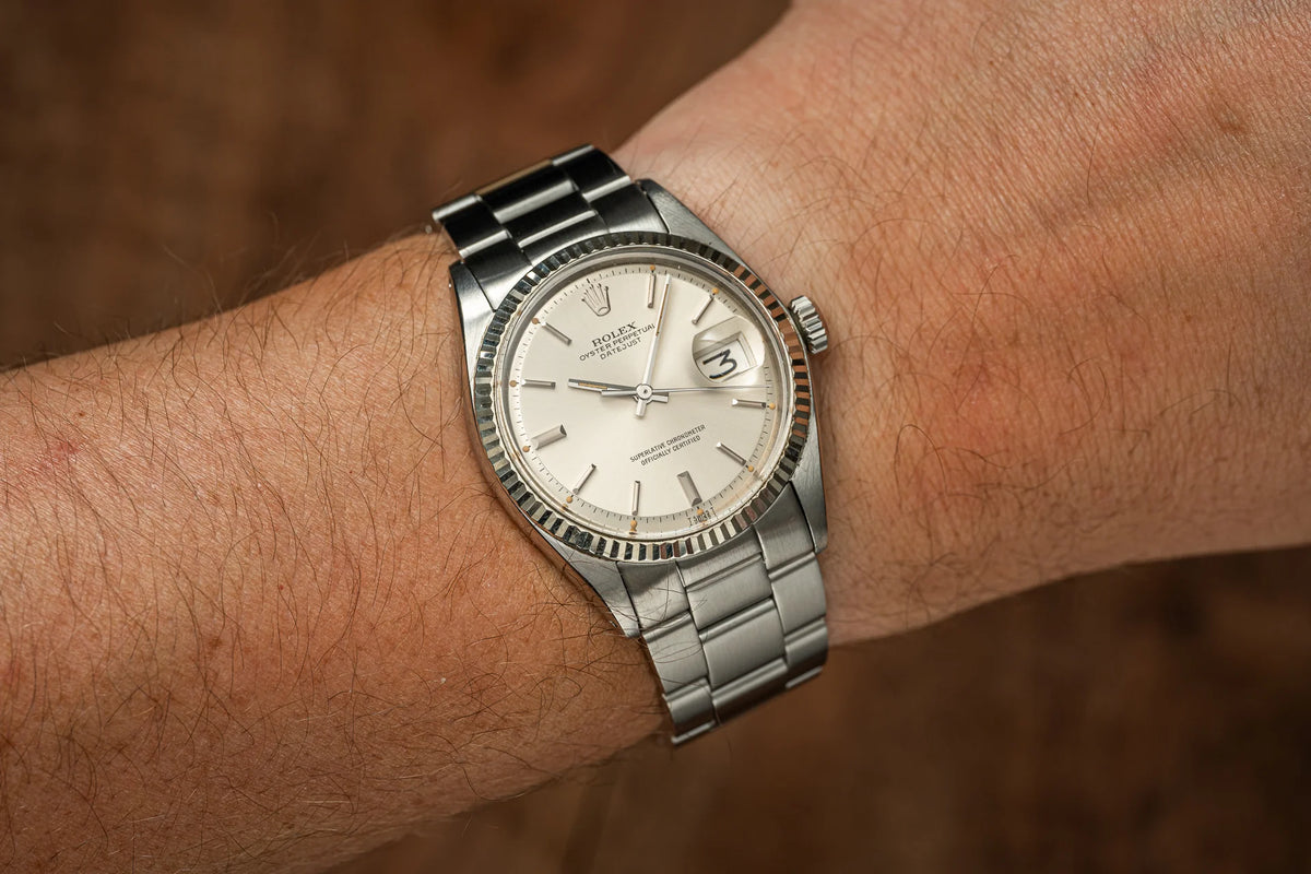 Vintage Rolex Datejust stainless steel watch with fluted bezel and silver dial on wrist