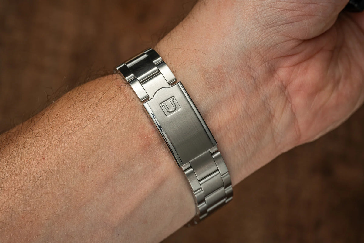 Stainless steel watch bracelet with solid link band and deployant clasp worn on wrist, compatible with classic Rolex Datejust models