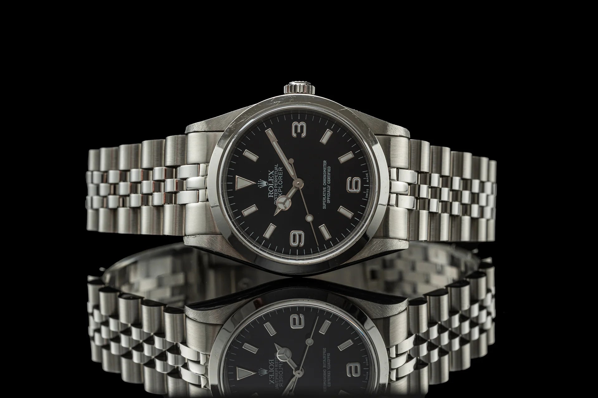 Stainless steel bracelet watch with black dial, applied indices, and jubilee-style metal band on black background