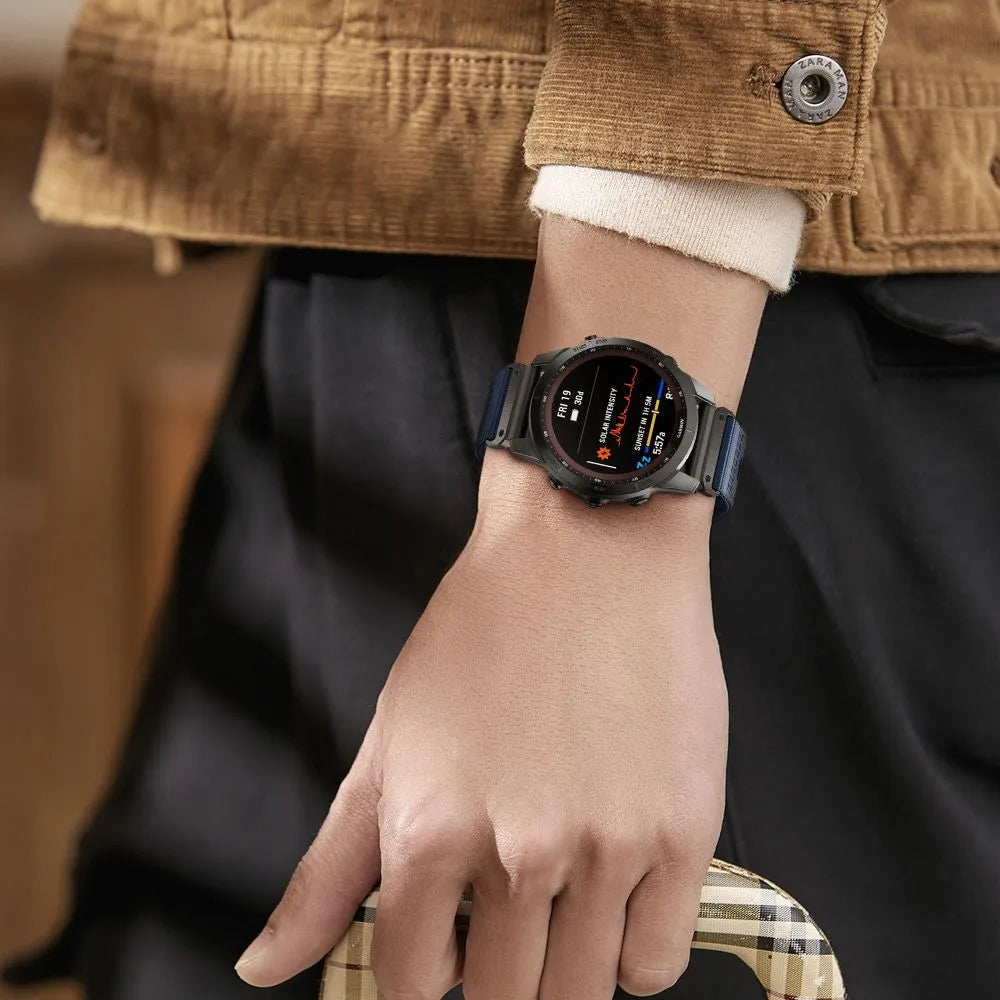 Black smartwatch with QuickFit strap worn on wrist, displaying digital face with fitness metrics and time