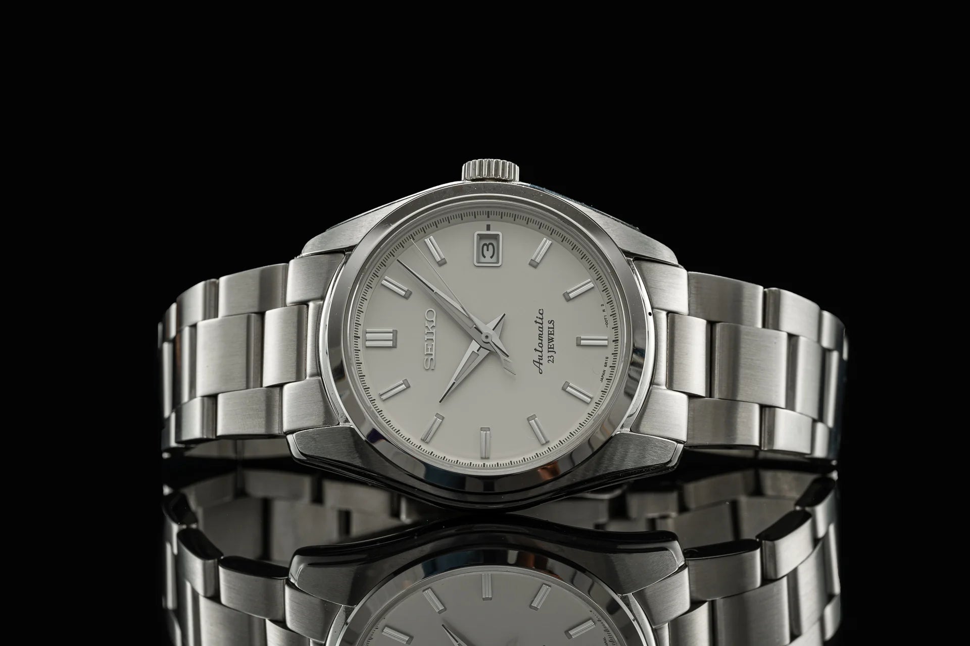 Seiko Alpinist stainless steel automatic watch with silver dial and metal bracelet on black background