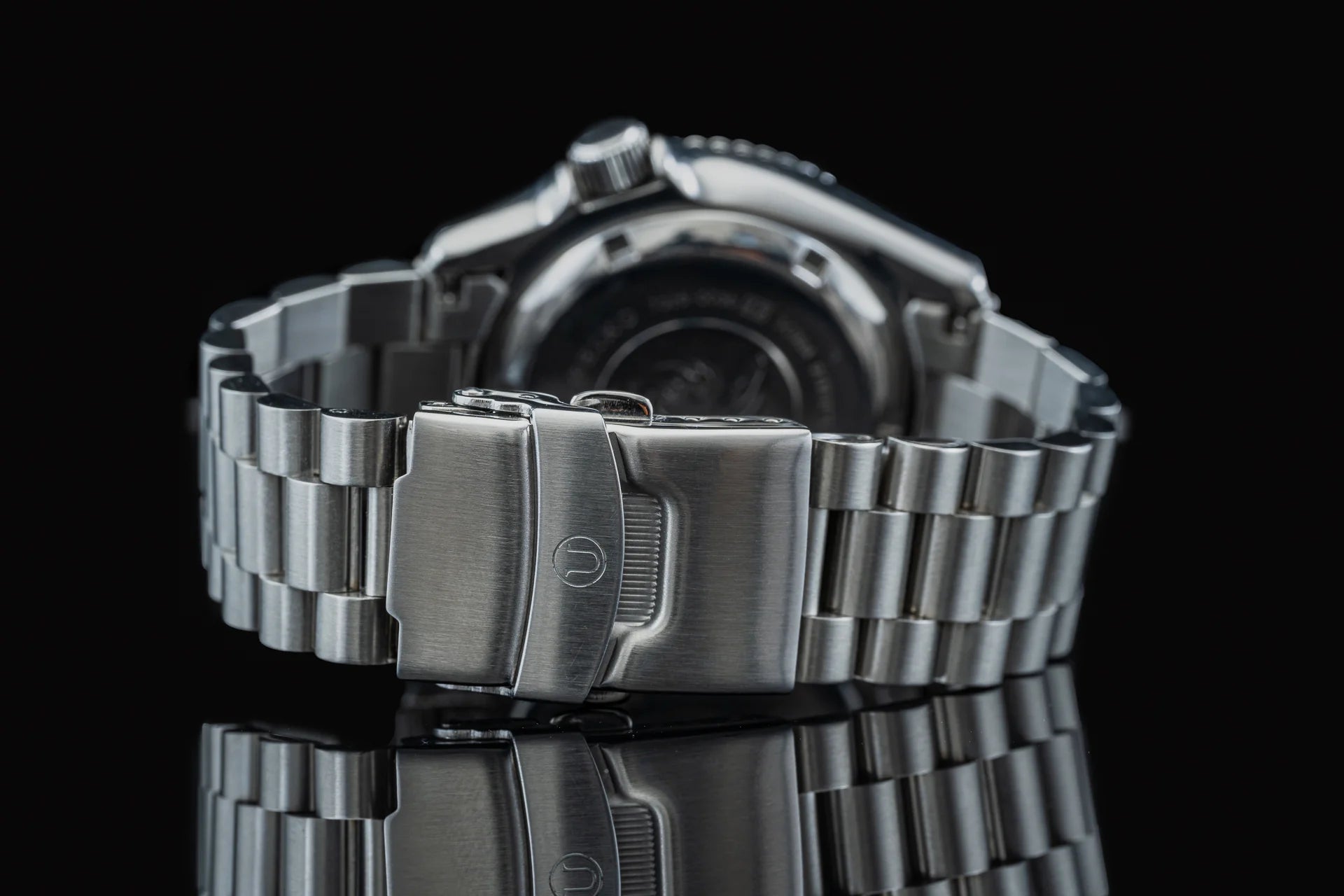Stainless steel bracelet with fold-over clasp for Seiko SKX013 dive watch, shown on black background