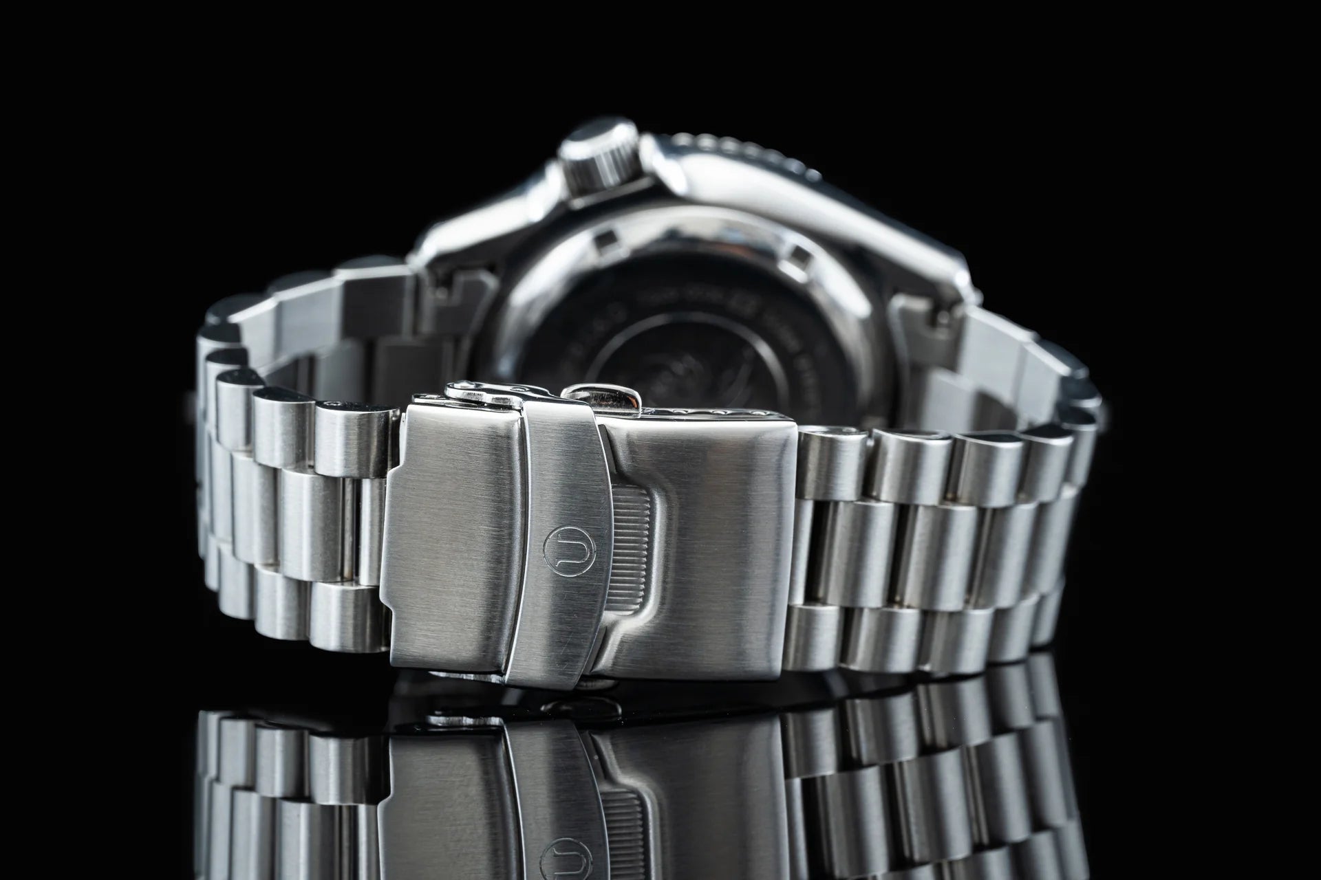 Stainless steel bracelet with fold-over clasp for Seiko SKX013 dive watch, shown on black background