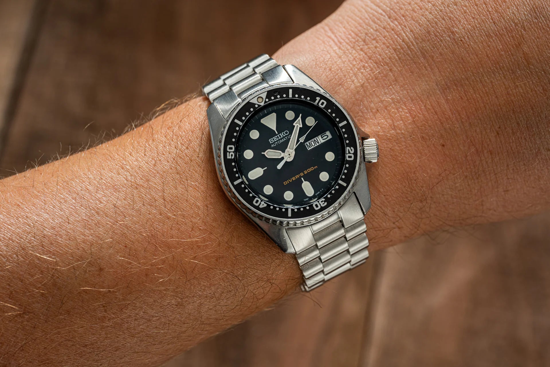 Seiko SKX013 stainless steel diver watch with black dial and luminous markers on wrist