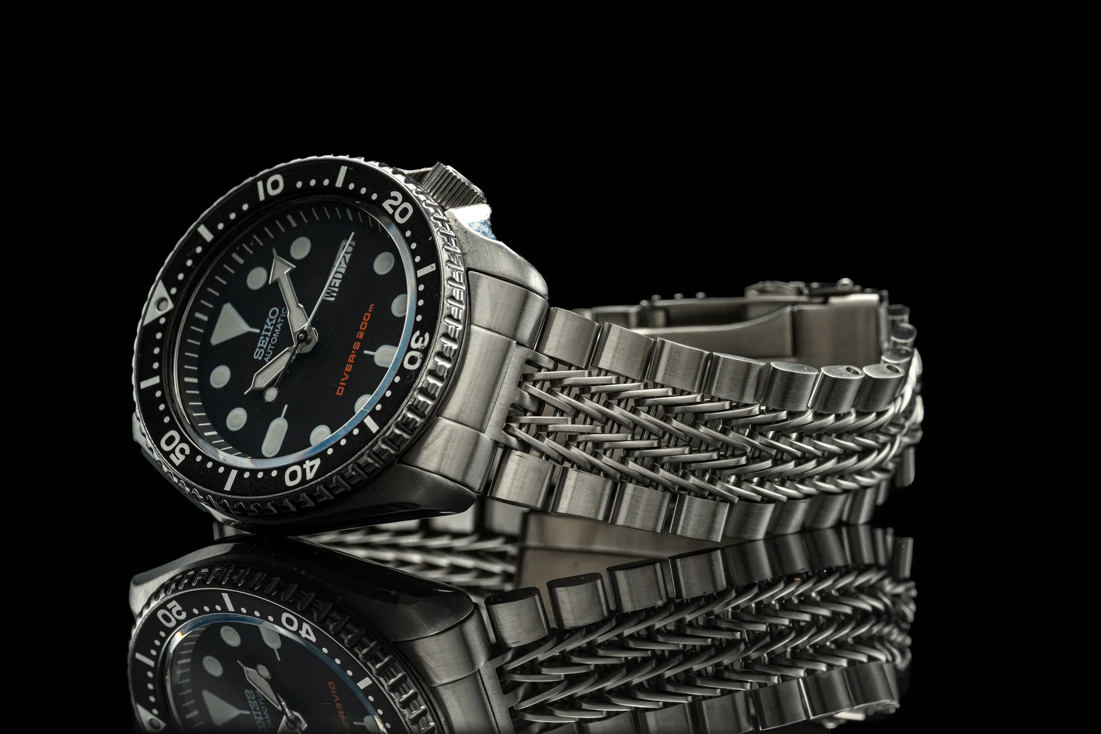 Seiko SKX007 diver watch with stainless steel razor-wire bracelet, black dial, rotating bezel, luminous hour markers on reflective surface