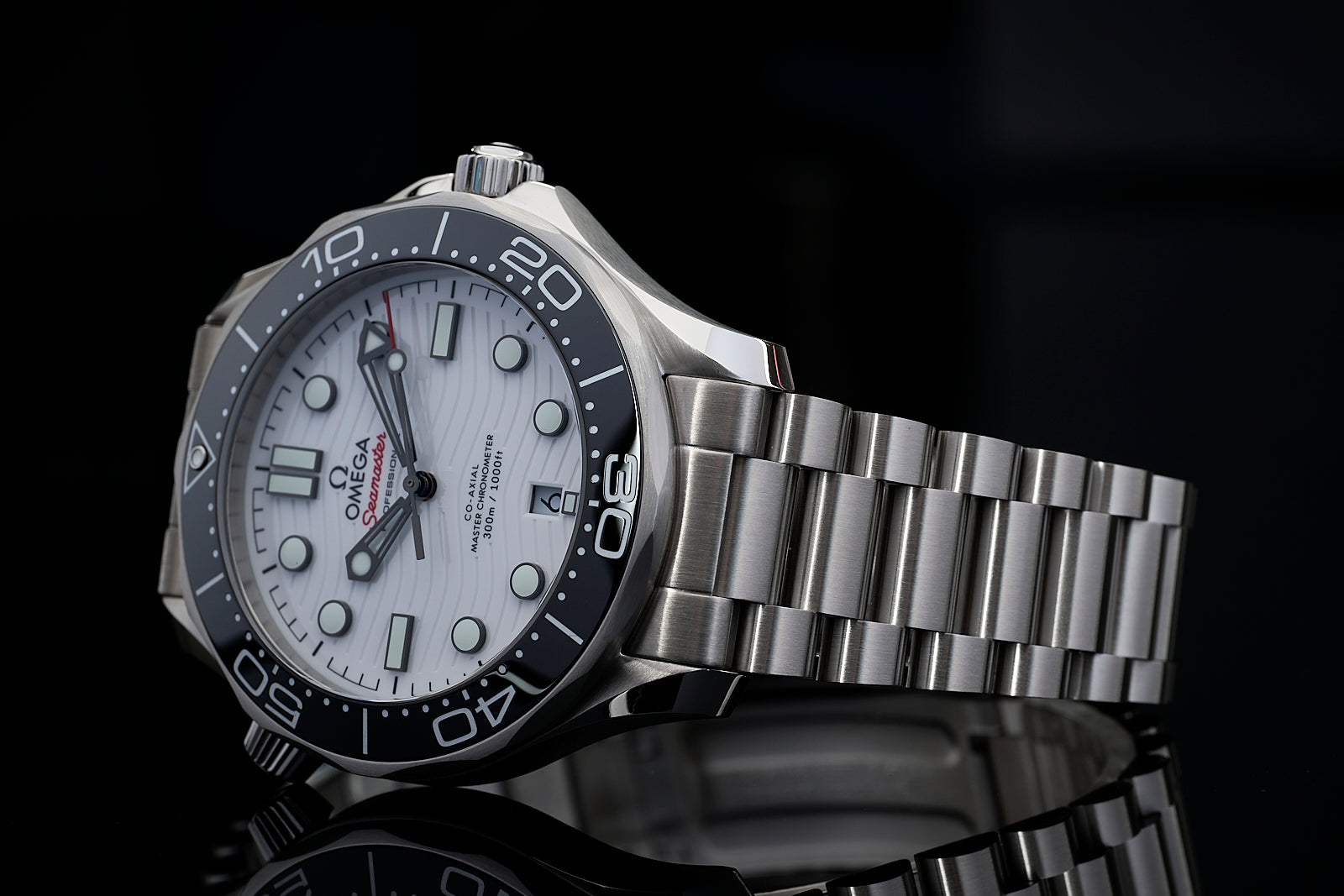Omega Seamaster 300M professional dive watch with white dial, black ceramic bezel, and stainless steel bracelet on black background