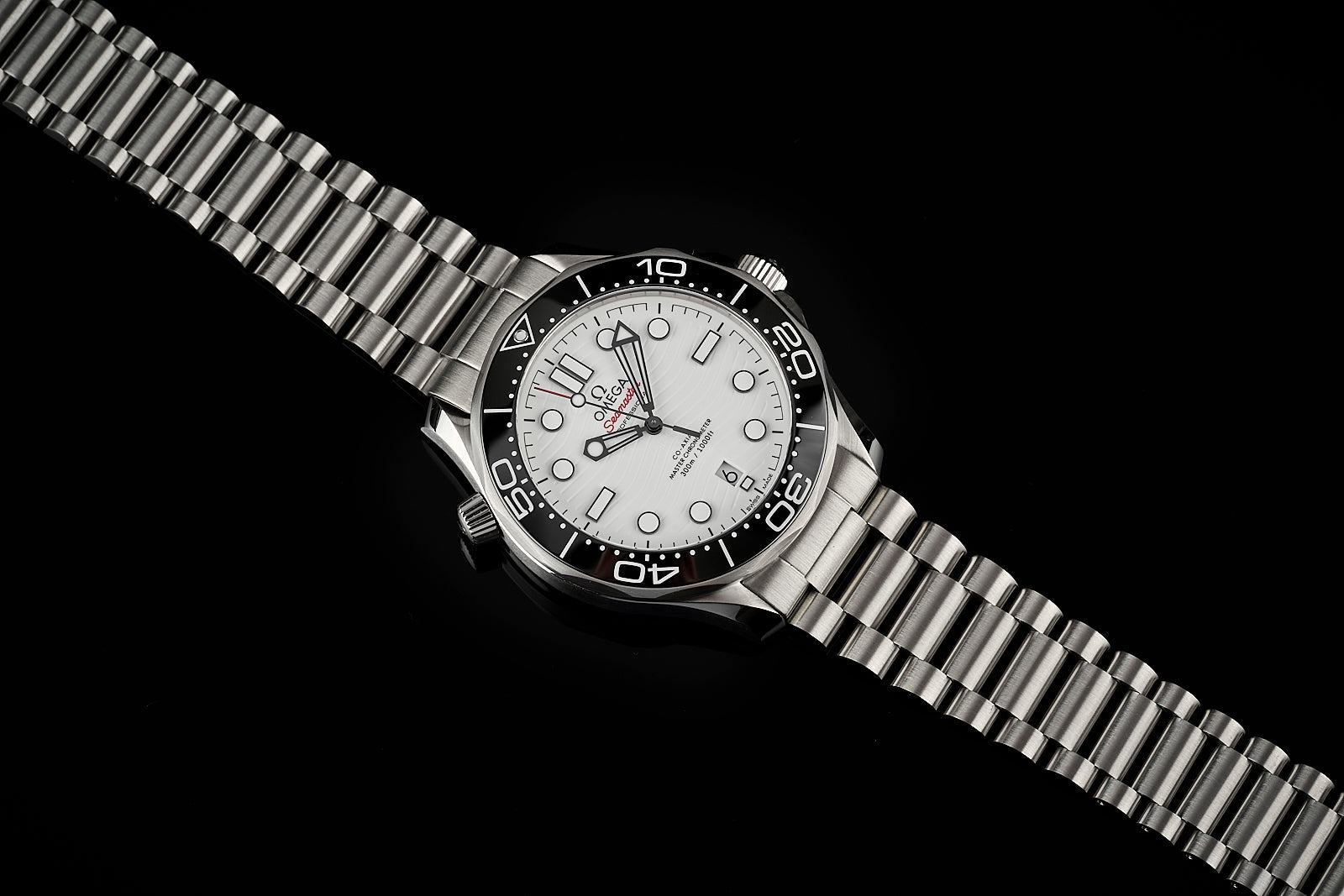 Omega Seamaster 300m dive watch with white dial, black bezel, and stainless steel bracelet on black background