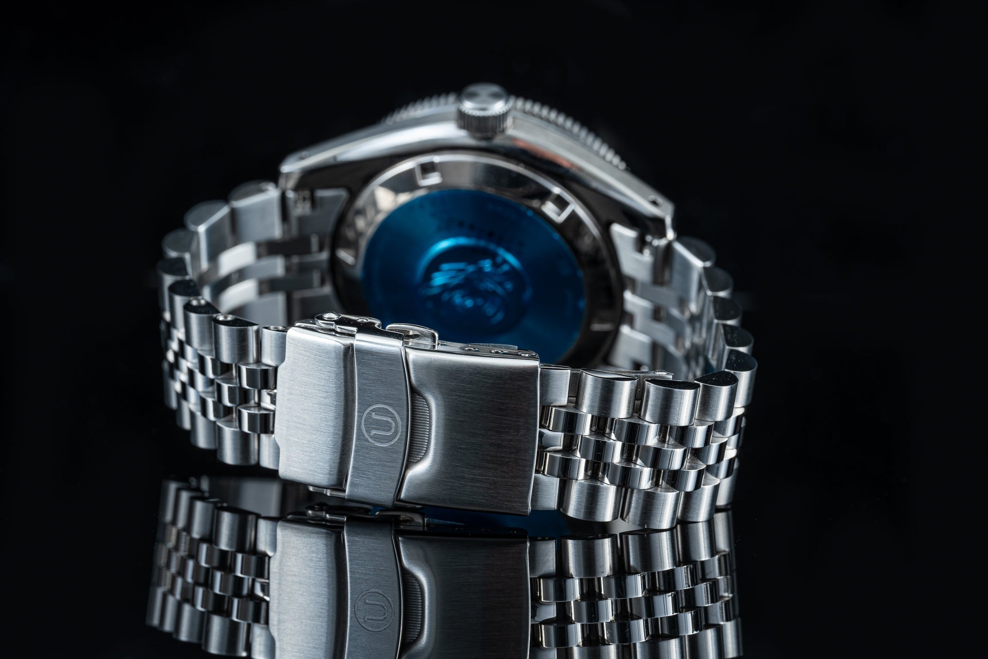 Stainless steel automatic dive watch with blue dial and matching metal bracelet, featuring rotating bezel and fold-over clasp