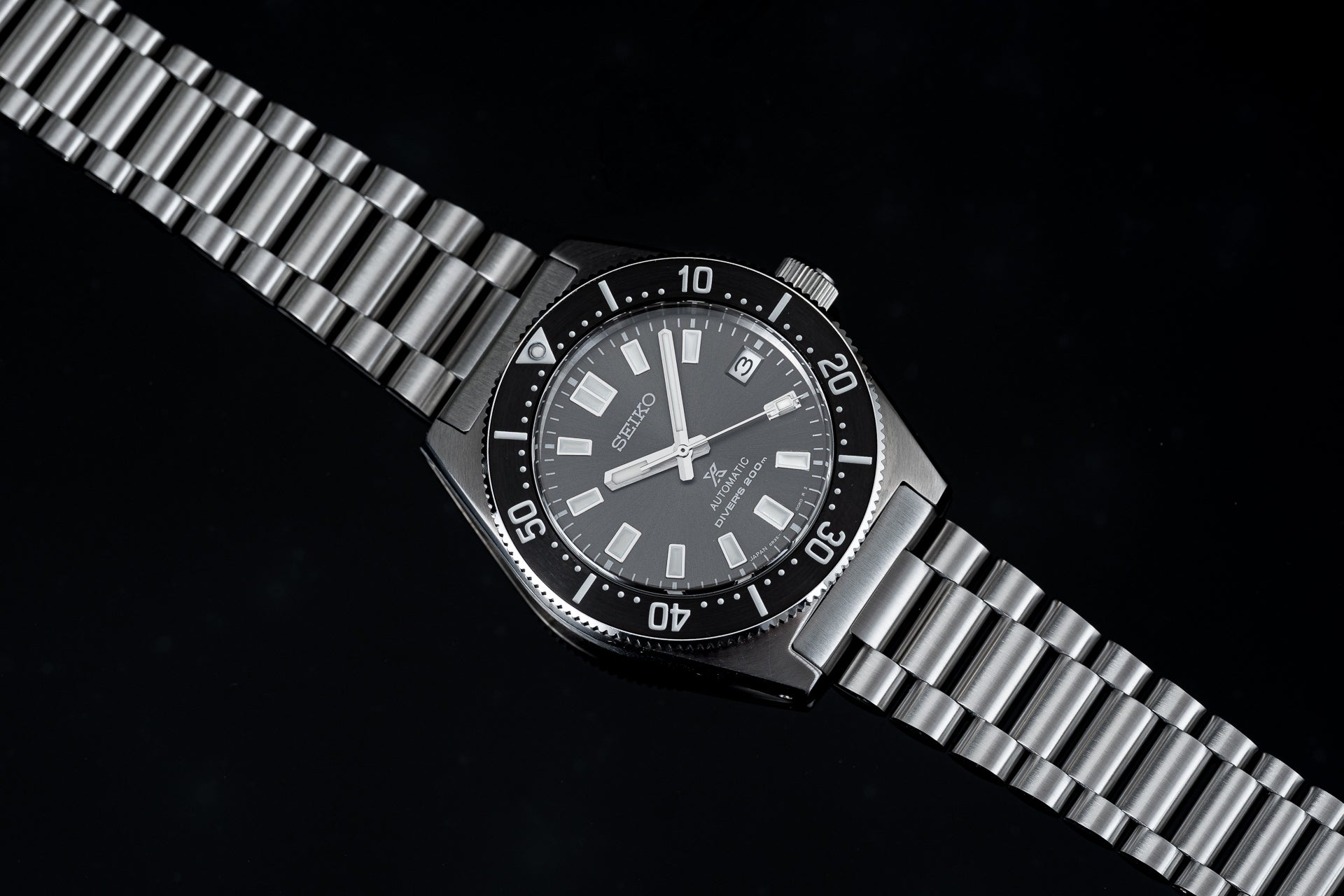 Seiko SPB149 62MAS reissue dive watch with black dial, rotating bezel, and stainless steel bracelet on black background