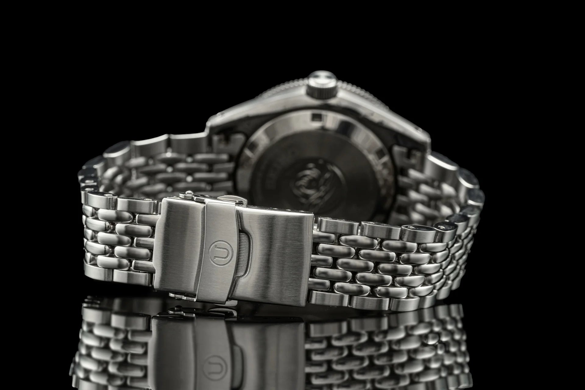 Stainless steel Seiko SPB45x dive watch with beads of rice bracelet and fold-over clasp on black background