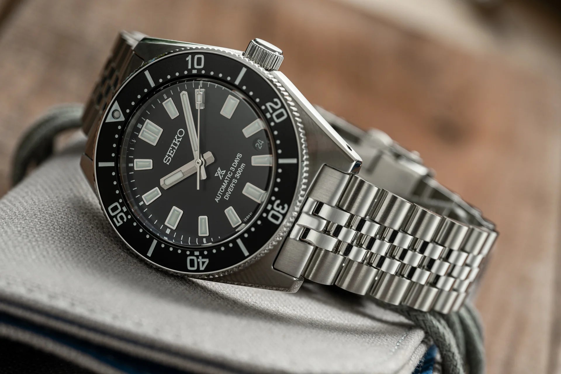 Seiko SPB45x automatic diver watch with black dial, stainless steel bracelet and rotating bezel on fabric background
