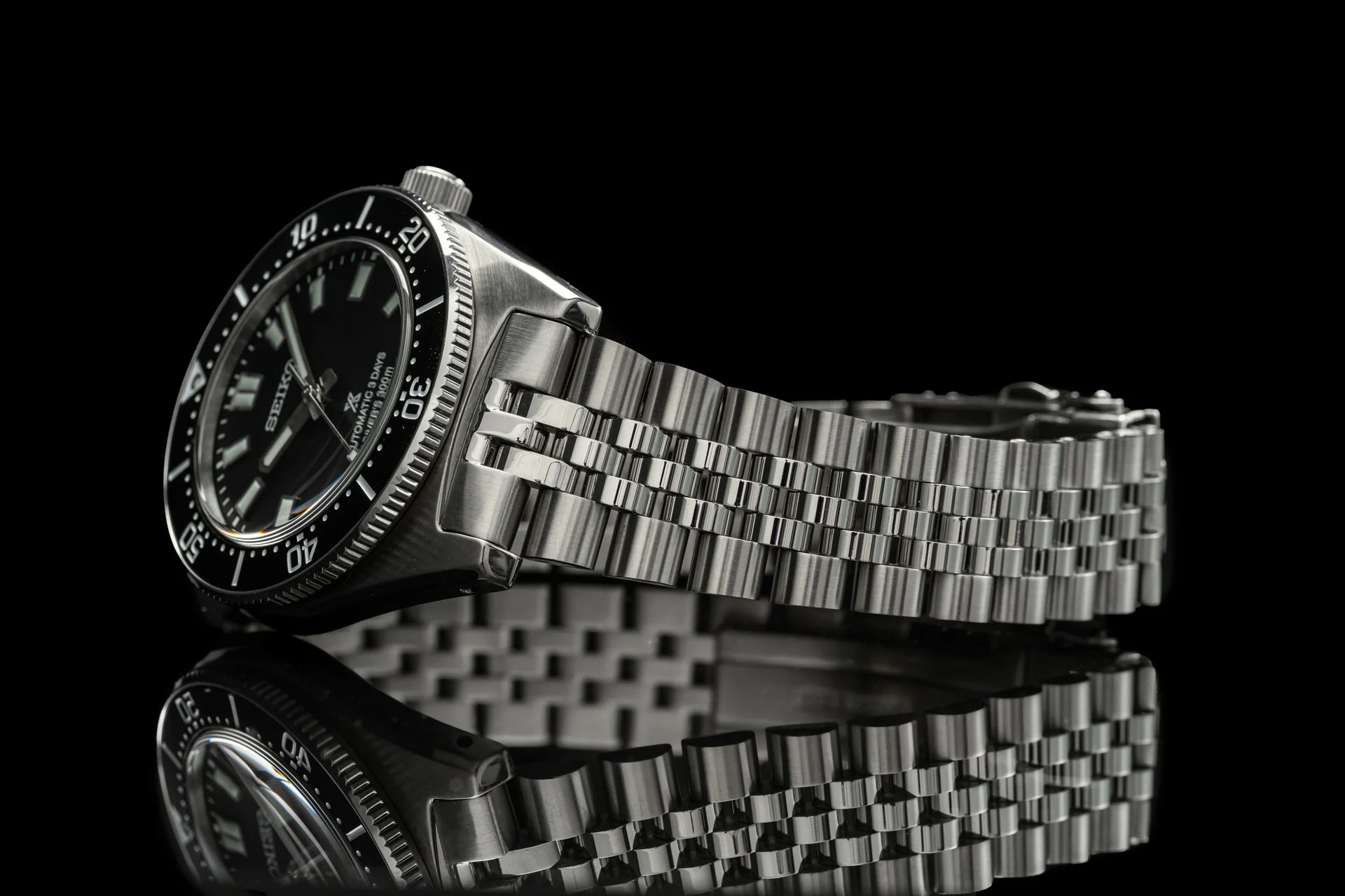 Seiko SPB45x Executive stainless steel diving watch with black dial and metal bracelet on black background