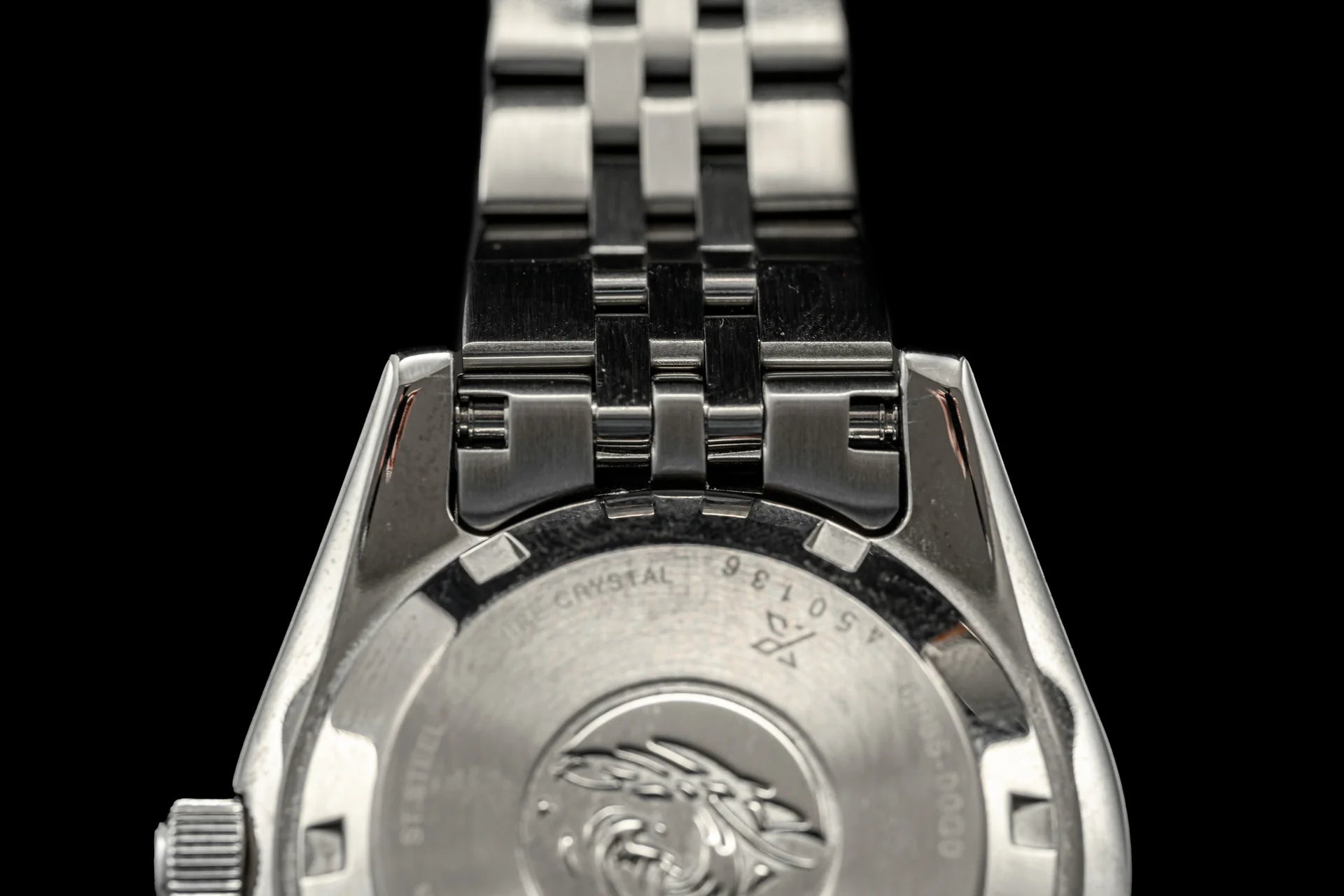 Stainless steel three-link bracelet with solid end links for luxury sports watch, detailed clasp mechanism visible