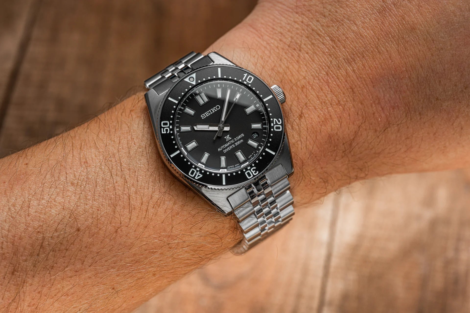Seiko automatic dive watch with black dial and stainless steel bracelet worn on wrist