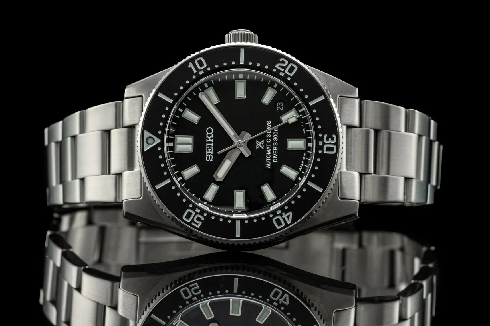 Seiko Prospex stainless steel dive watch with black dial, luminous markers, rotating bezel, and metal bracelet