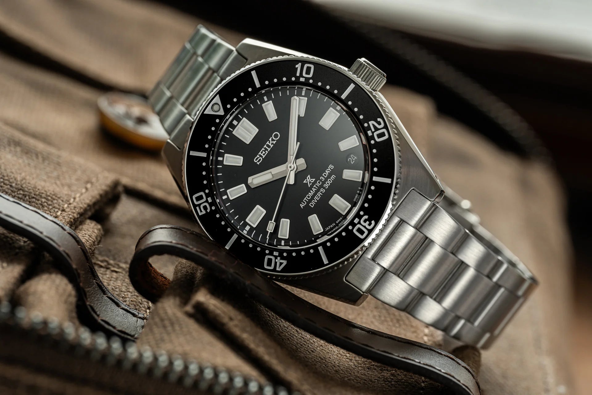 Seiko automatic diver watch with black dial, stainless steel bracelet and rotating bezel on canvas strap