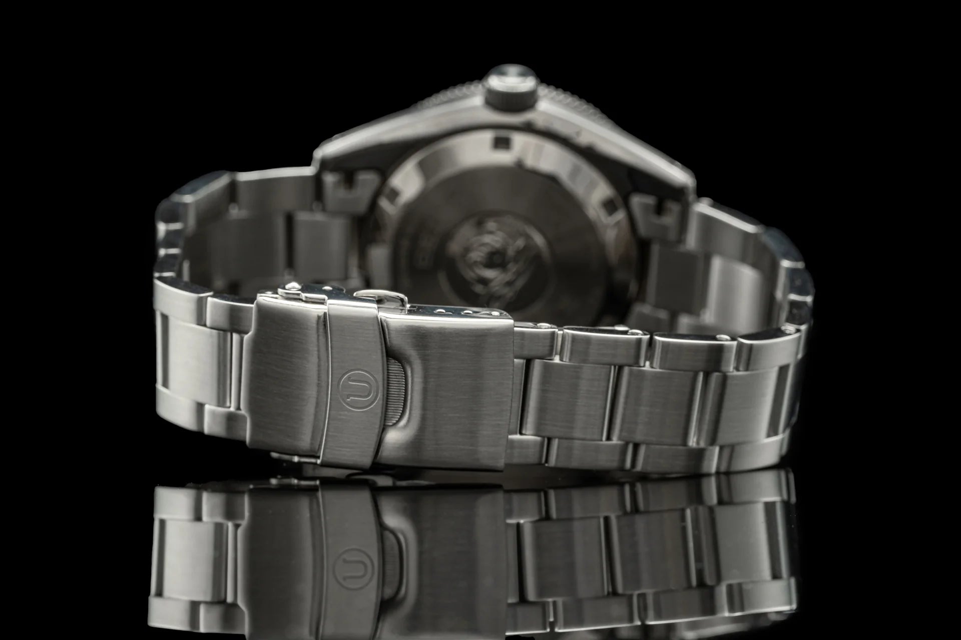 Stainless steel sports watch with matching metal bracelet and push-button clasp, featuring dark dial and rotating bezel on black background