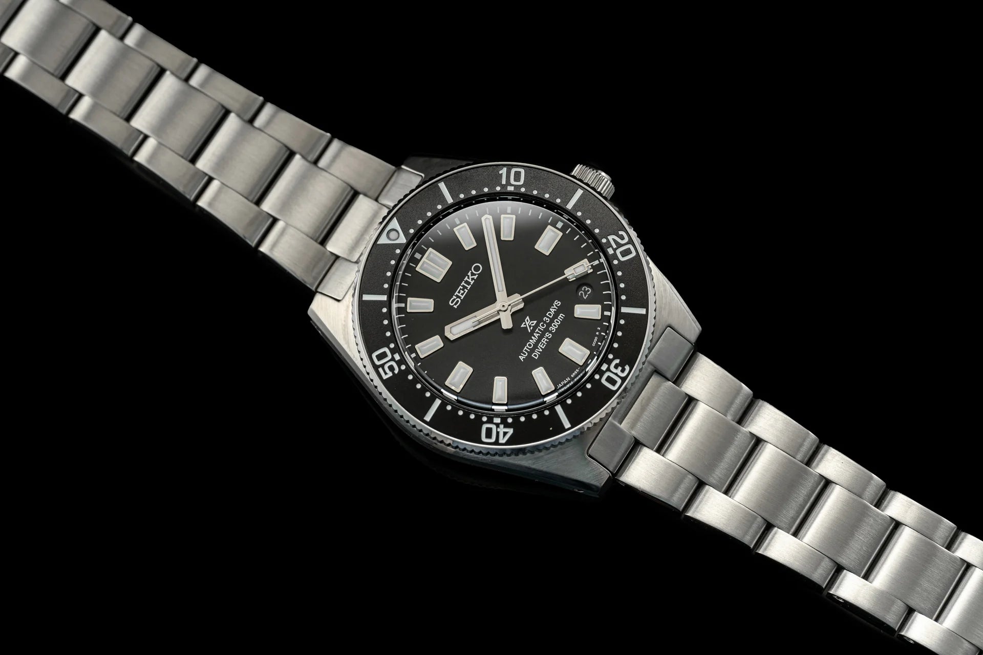 Seiko Prospex SPB45x automatic dive watch with stainless steel bracelet and black dial on black background