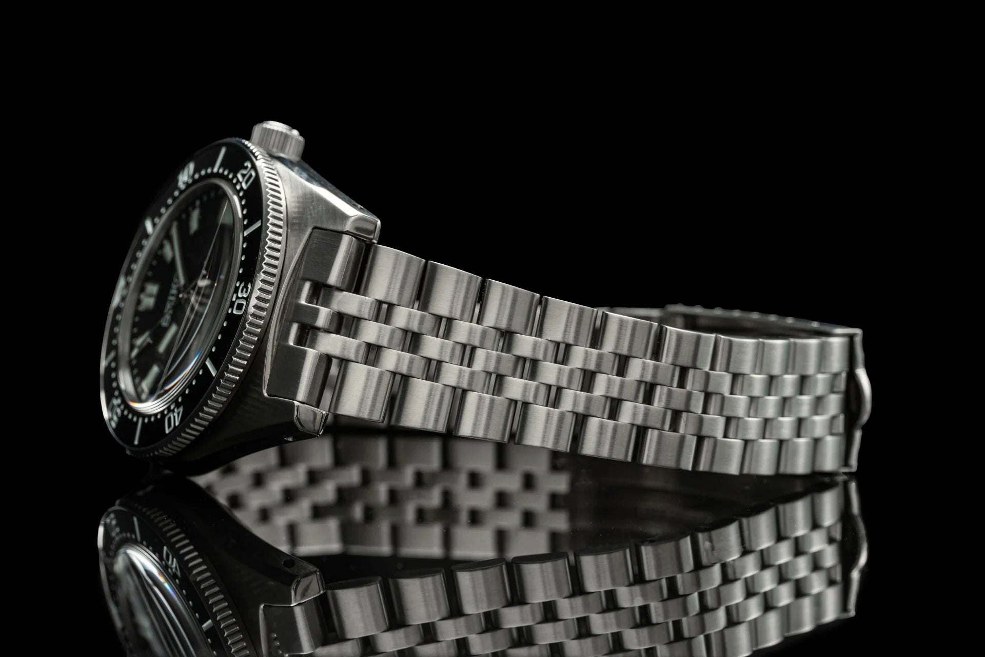 Seiko SPB45x automatic diving watch with stainless steel bracelet and black dial on reflective surface