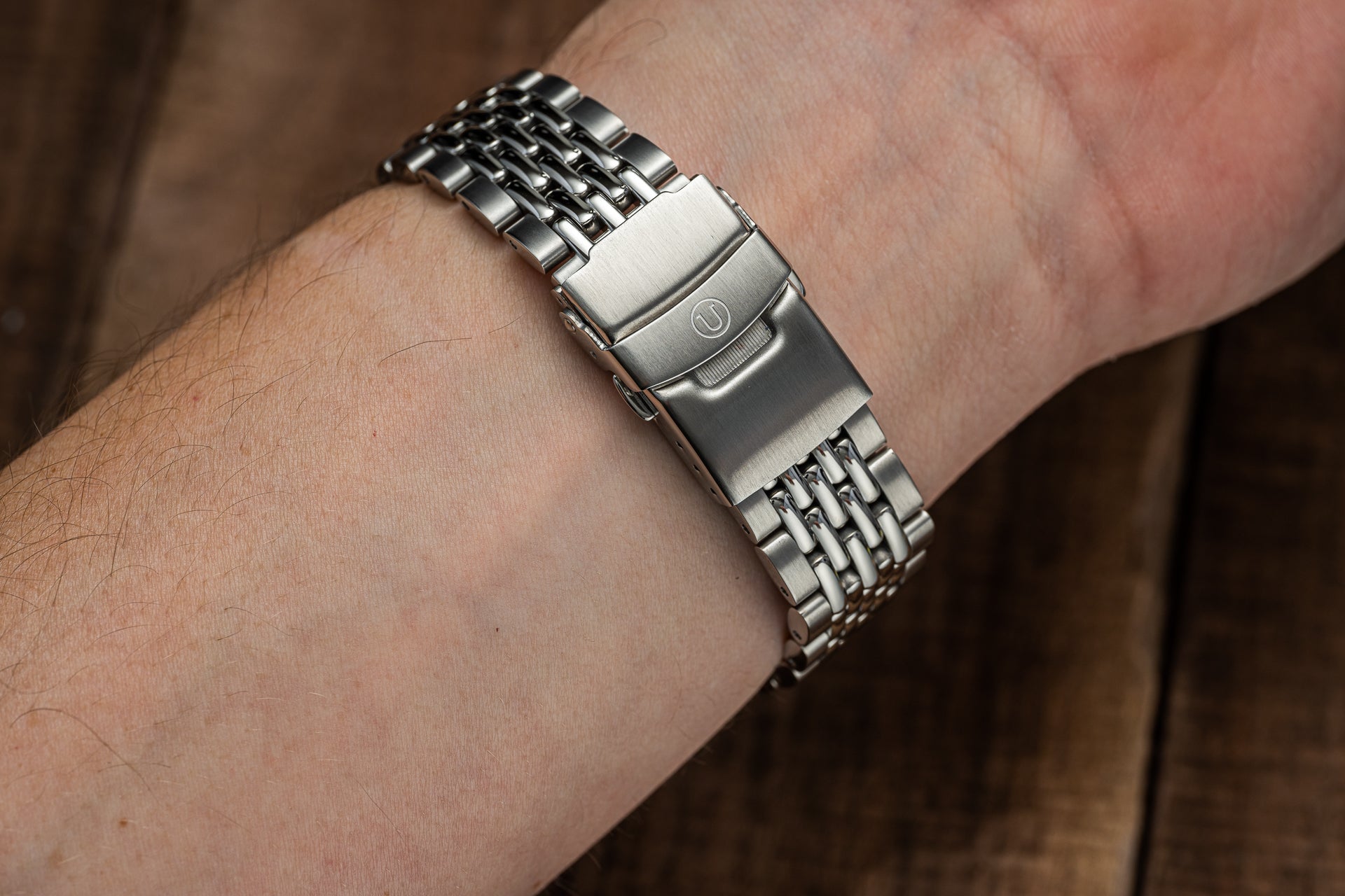 Silver beads of rice watch bracelet on male wrist, showing polished stainless steel links and secure clasp