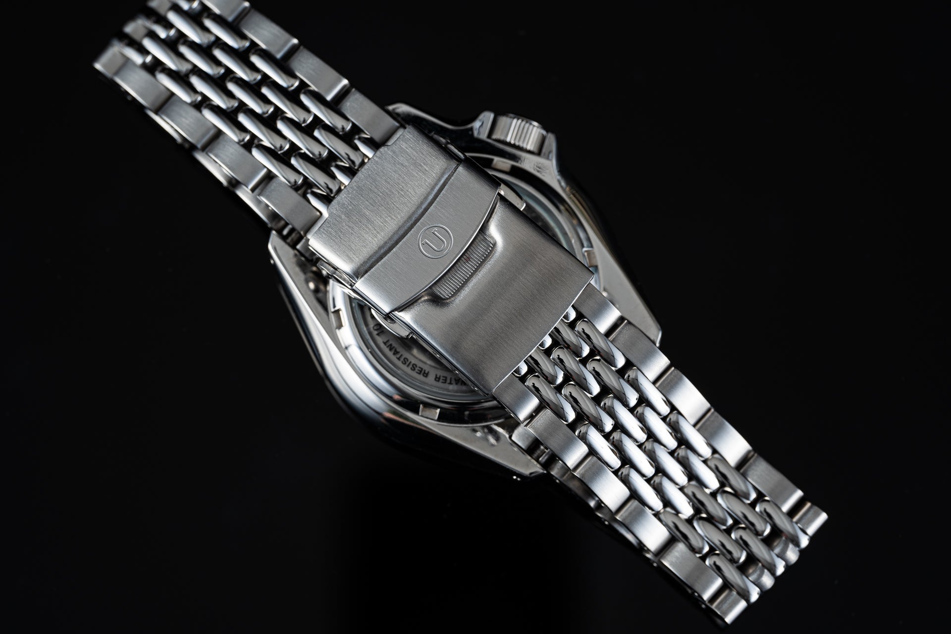 Seiko SRPK stainless steel watch with beads of rice bracelet, brushed metal finish on black background