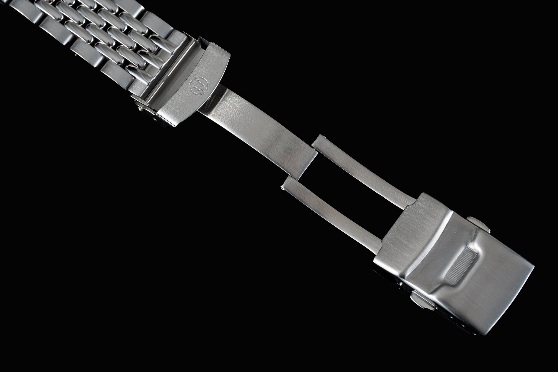 Stainless steel Beads of Rice bracelet for Seiko SRPK watch with polished links and secure clasp on black background