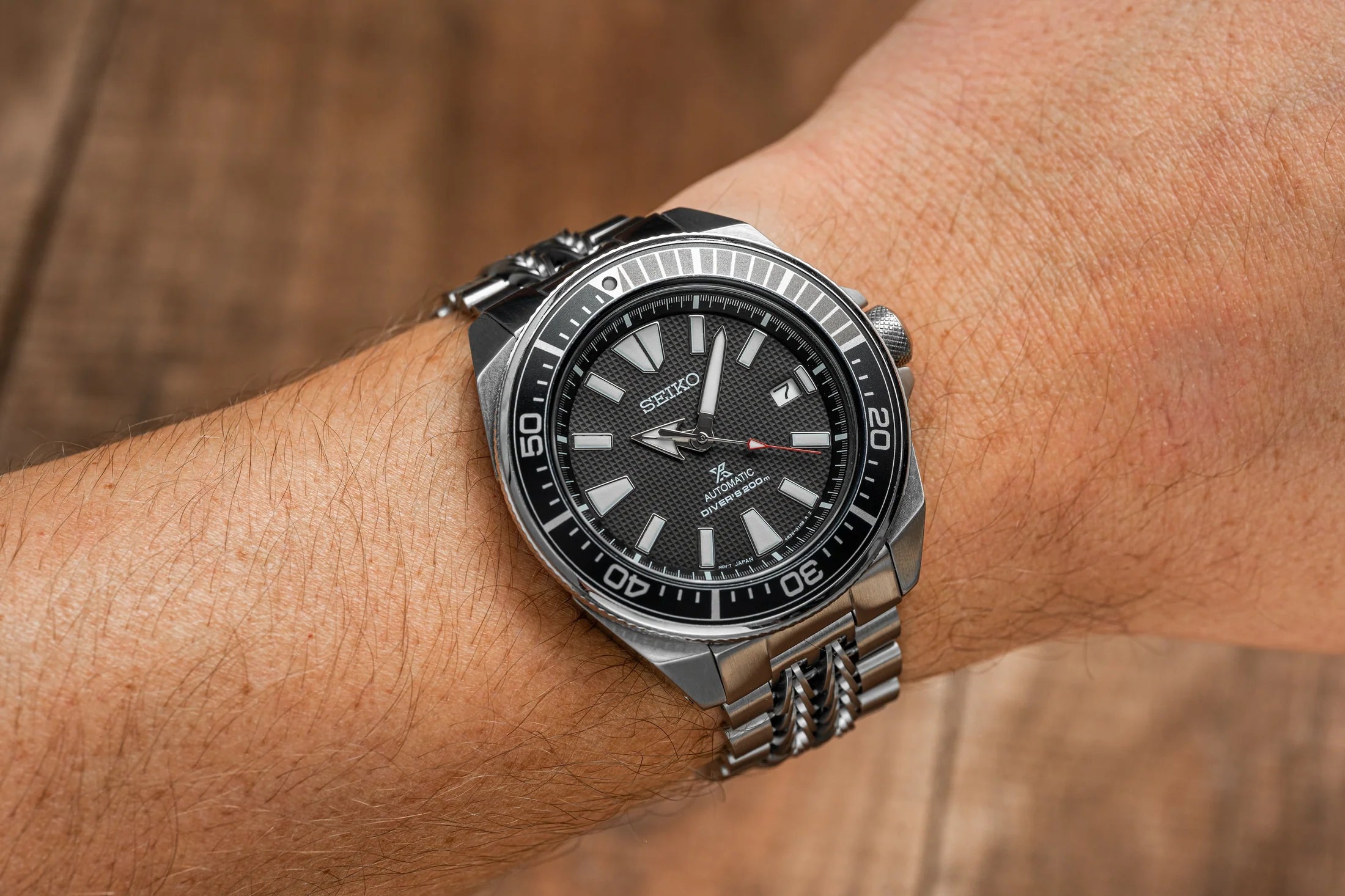 Seiko Samurai automatic diver watch with black dial and stainless steel bracelet on wrist