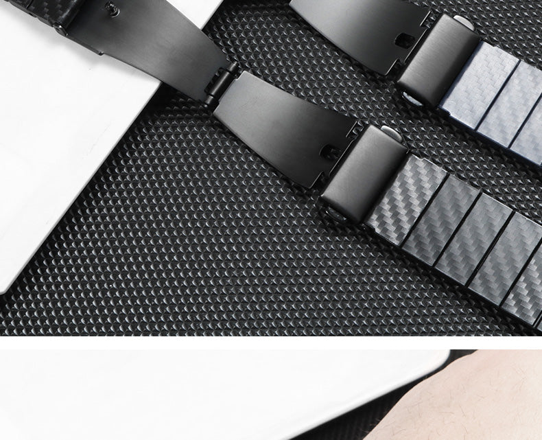 Carbon fiber quick release bracelet in blue with metal buckle on textured black background