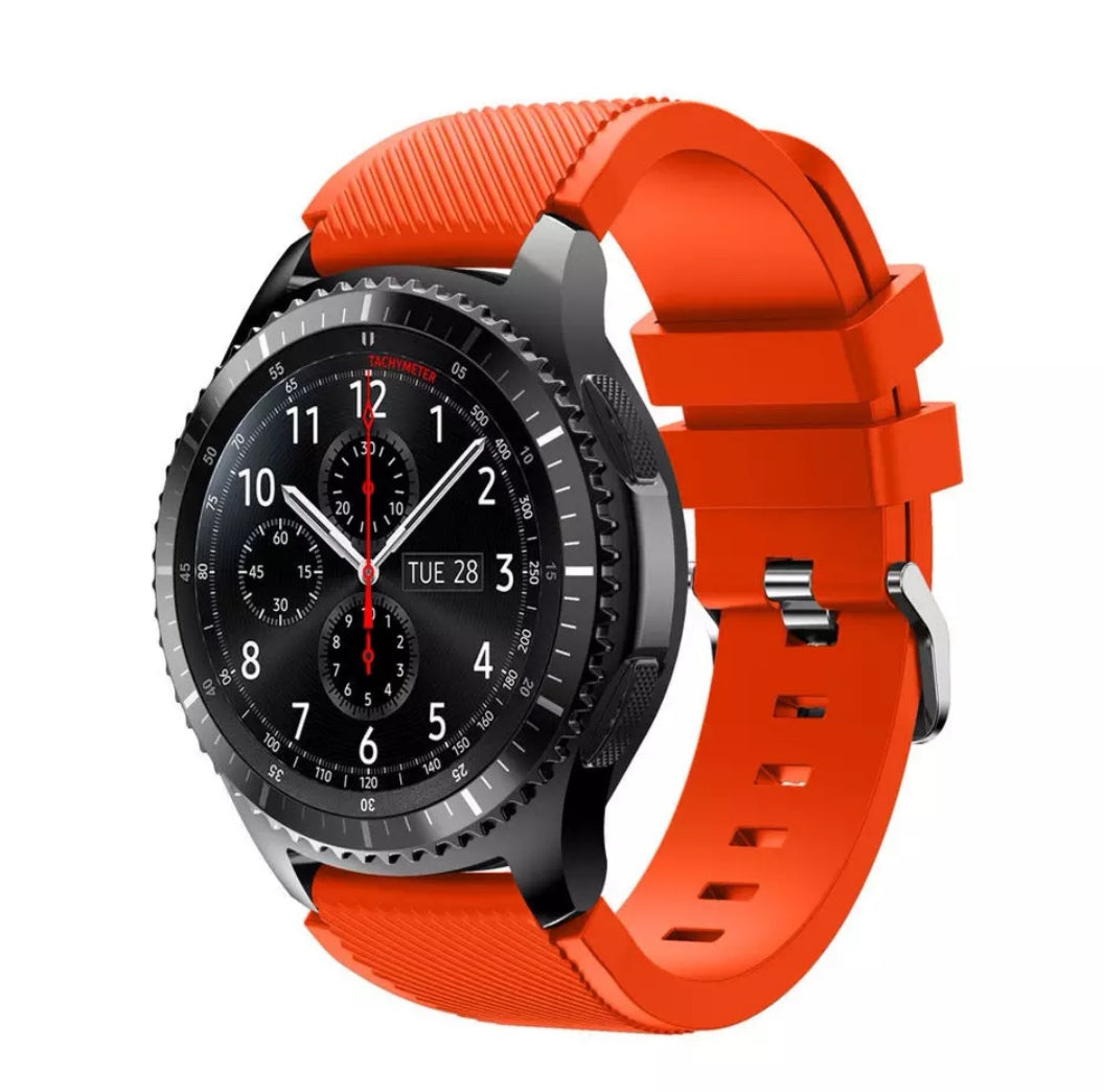 Smartwatch with black chronograph dial and bright orange silicone replacement band with textured strap and metal clasp