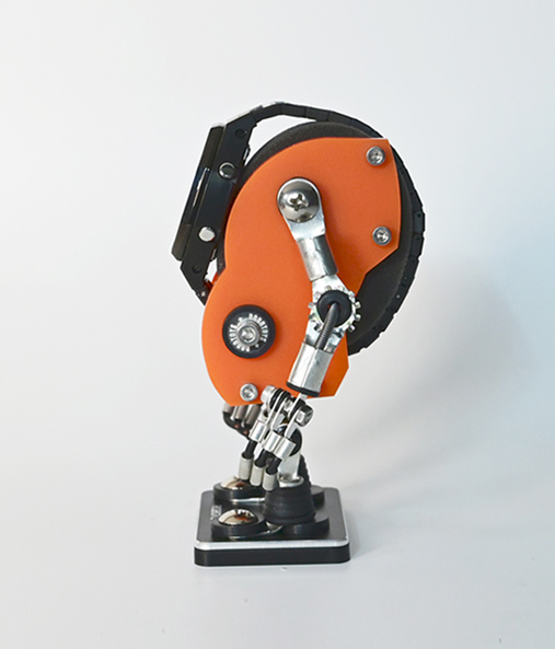 Orange and black robotic minibot watch stand with articulated metal arms and compass detail on display base