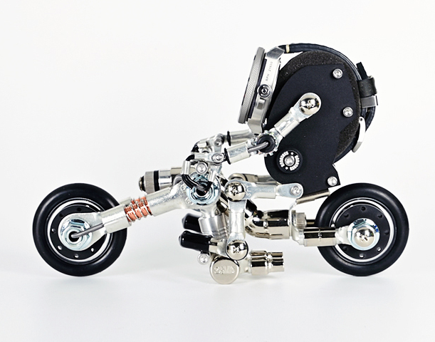 Black and silver mechanical watch stand in miniature motorcycle chopper design with detailed metal parts
