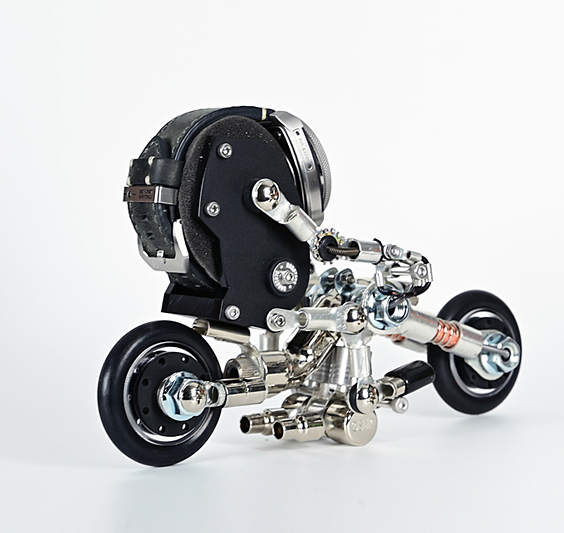 Black and silver robotic motorcycle watch stand with articulated metal frame and chrome wheels