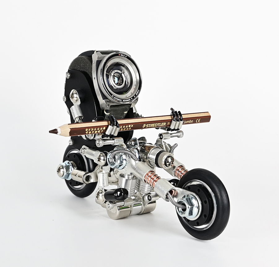 Steampunk RoboBike watch stand with camera head, metal frame, pencil handlebar and rotating wheels on white background