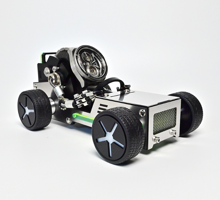DIY robotics car kit with LED headlight, black wheels, green stripe detail, and metal chassis on white background