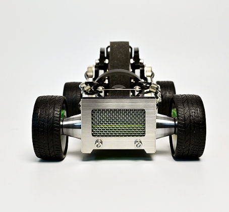 White and black toy roadster car with green accents, front view showing detailed chassis and black tires
