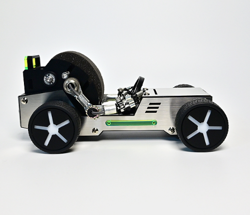 Cream and black metal watch stand designed as a vintage-style roadster car with white wheels and mechanical details
