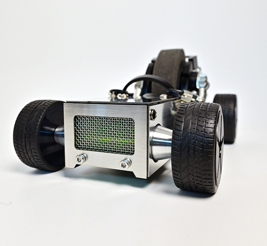 Miniature metal roadster car toy with black textured tires, chrome engine detail, and driver seat on white background