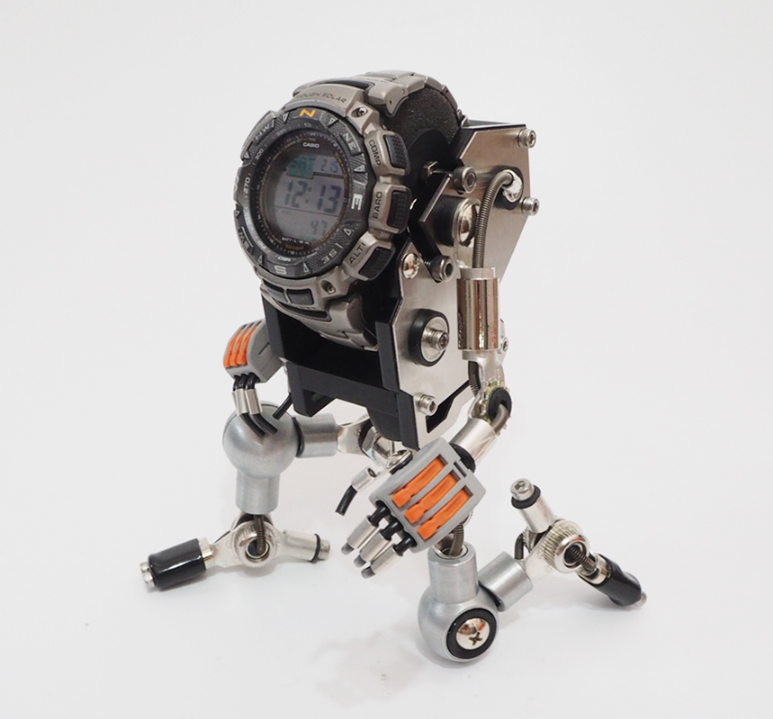 Silver RoboMech watch stand holding digital sports watch with articulated metal limbs and orange accents