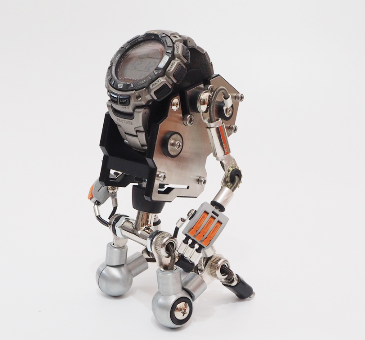RoboMech silver robot watch stand holding digital watch with articulated metal arms and wheels