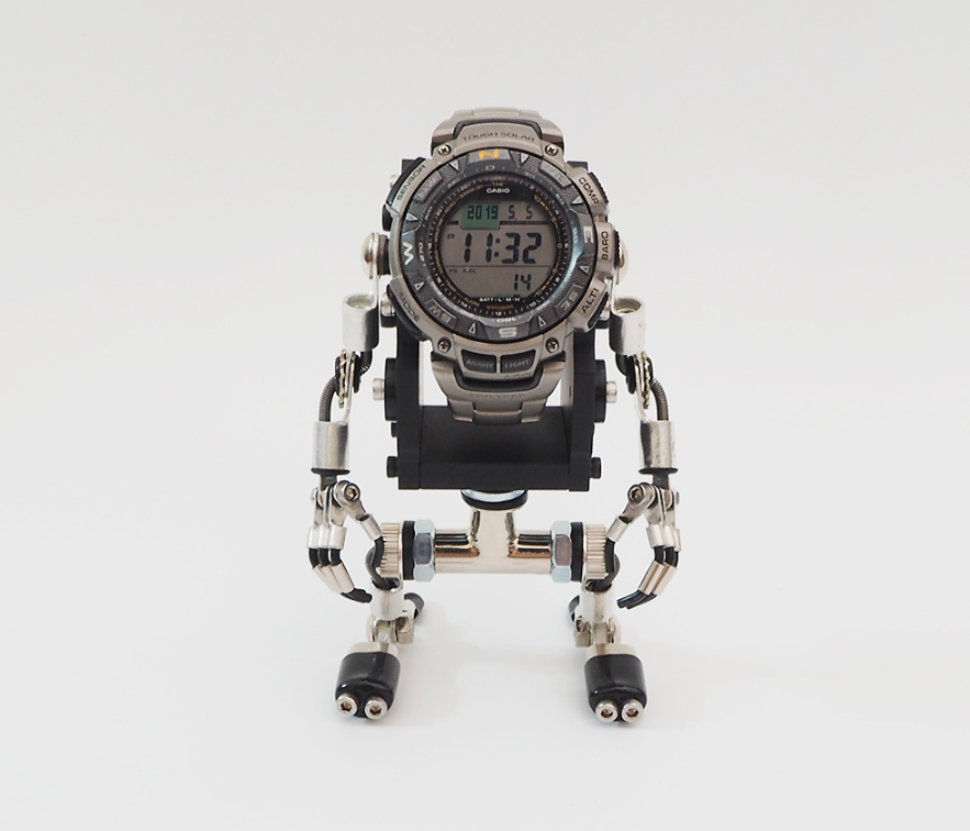 MiniMech black robot watch stand with articulated limbs holding digital watch