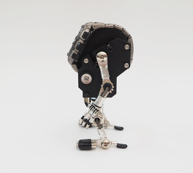Black MiniMech robotic watch stand with articulated metal limbs and mechanical details, displayed against white background